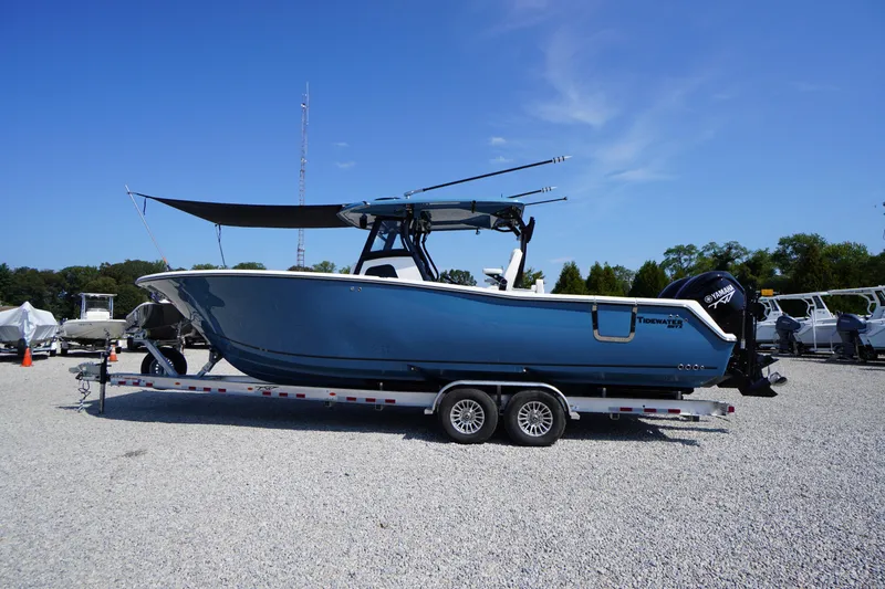Slide: The Image of 2026 Tidewater 302 CC Adventure boat on trailer, blue hull, sunny day, outdoor display. - 93
