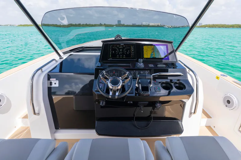 Slide: The Image of 2025 Pardo Yachts P38 dashboard with navigation and control systems, set against a turquoise sea backdrop. - 34