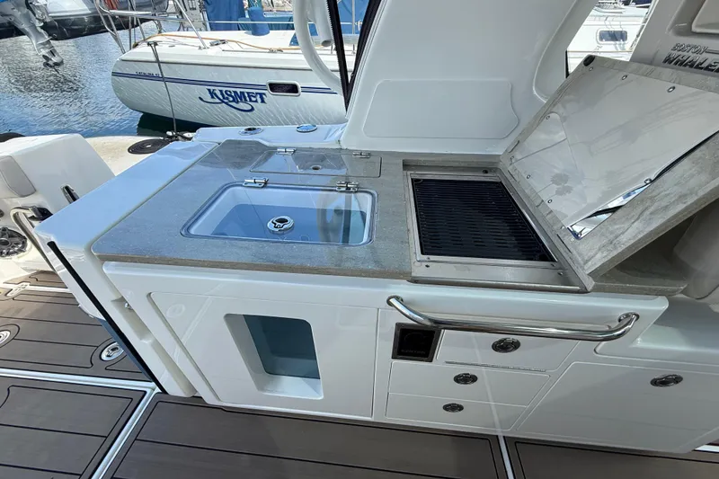 Slide: The Image of 2023 Boston Whaler 380 Realm boat kitchen with sink and grill. - 11
