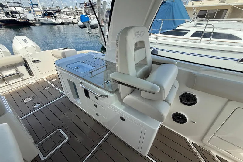 Slide: The Image of 2023 Boston Whaler 380 Realm interior with seating and deck, docked at marina. - 14