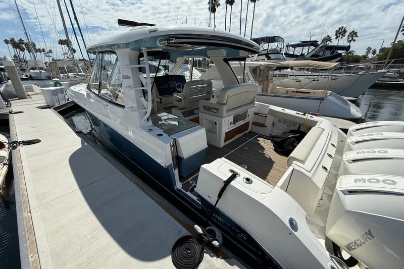 Slide: The Image of 2023 Boston Whaler 380 Realm docked, showcasing sleek design and powerful engines. - 2