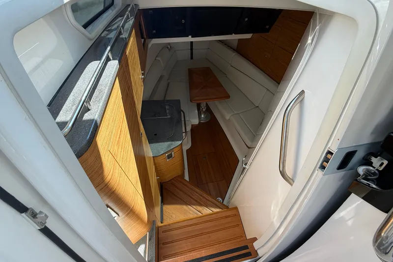 Slide: The Image of 2023 Boston Whaler 380 Realm interior with wood accents and seating area. - 23