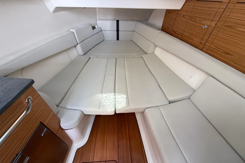 Slide: The Image of 2023 Boston Whaler 380 Realm interior with white seating and wooden cabinetry. - 28