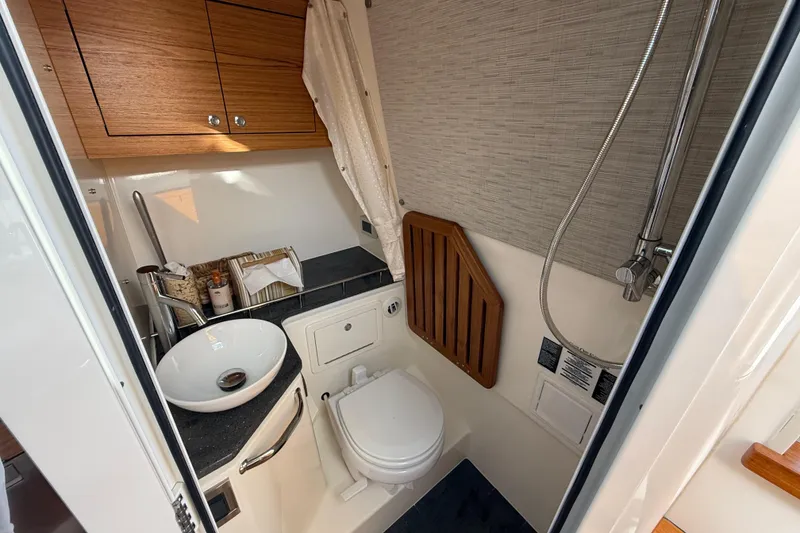 Slide: The Image of Luxurious bathroom in 2023 Boston Whaler 380 Realm boat, featuring modern fixtures and wood accents. - 29