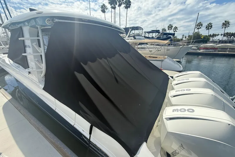 Slide: The Image of 2023 Boston Whaler 380 Realm with black cover and multiple outboard engines docked at marina. - 34