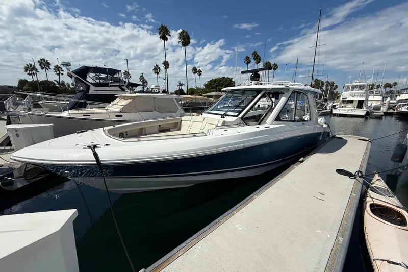 Slide: The Image of 2023 Boston Whaler 380 Realm docked at marina under blue sky. - 4