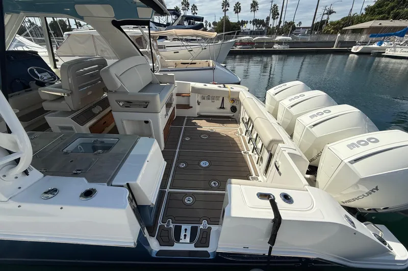 Slide: The Image of 2023 Boston Whaler 380 Realm boat interior with Mercury engines, docked in a marina. - 5