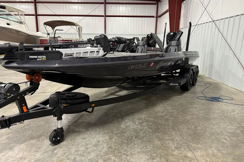 Slide: The Image of 2024 iKon LX21 boat in a warehouse, featuring Minn Kota motor and dual axle trailer. - 1