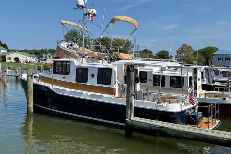 Slide: The Image of 2023 Ranger Tugs R-31 CB docked at marina, featuring classic design and modern amenities. - 2