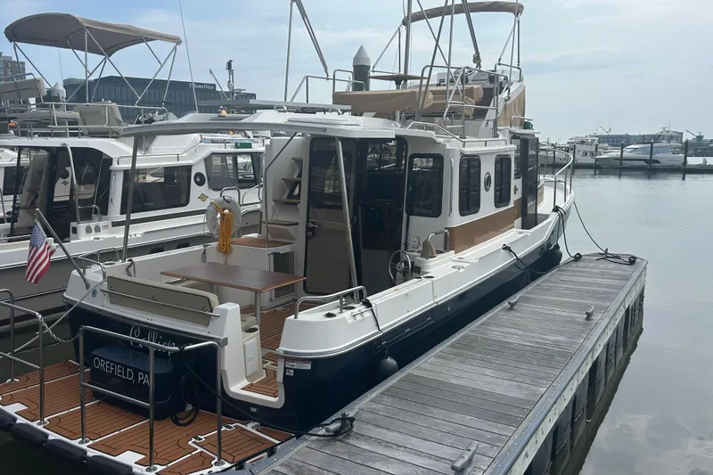 Slide: The Image of 2023 Ranger Tugs R-31 CB docked at a marina, showcasing its spacious deck and cabin. - 4