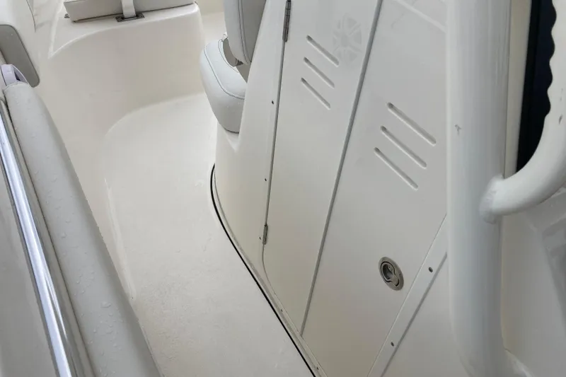 Slide: The Image of 2026 Key West 260 Center Console interior, featuring sleek white seating and storage compartment. - 8