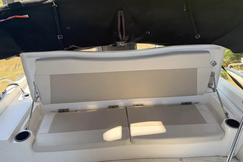 Slide: The Image of 2017 Boston Whaler 180 Dauntless boat seating area with cup holders and sunshade. - 9