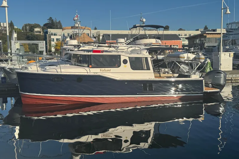 The Image of 2025 Ranger Tugs R-27 boat docked in marina, reflecting on calm water. - 0