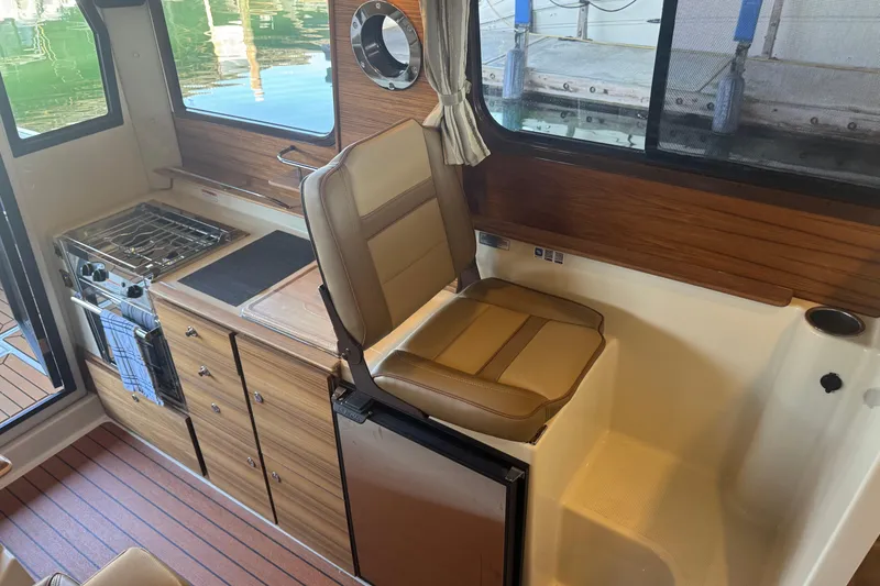 Slide: The Image of Interior of 2025 Ranger Tugs R-27 with kitchenette and seating area. - 14