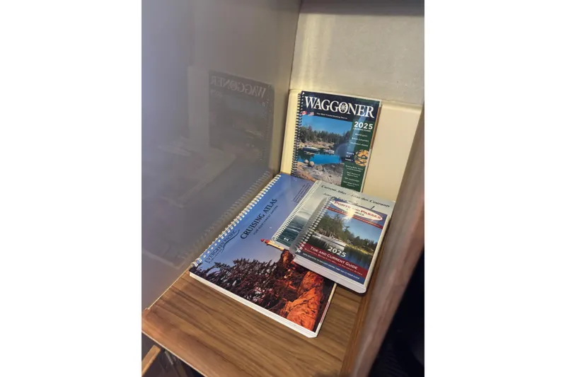 Slide: The Image of 2025 boating guides and maps on a Ranger Tugs R-27 shelf. - 19