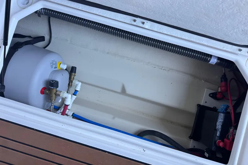 Slide: The Image of 2025 Ranger Tugs R-27 boat compartment with water heater and electrical components. - 25