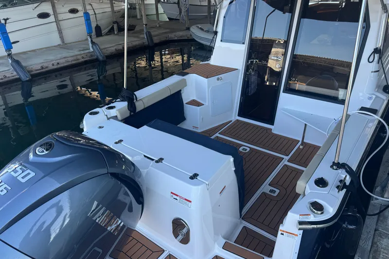 Slide: The Image of 2025 Ranger Tugs R-27 boat with Yamaha engine, docked, featuring spacious deck and seating. - 6