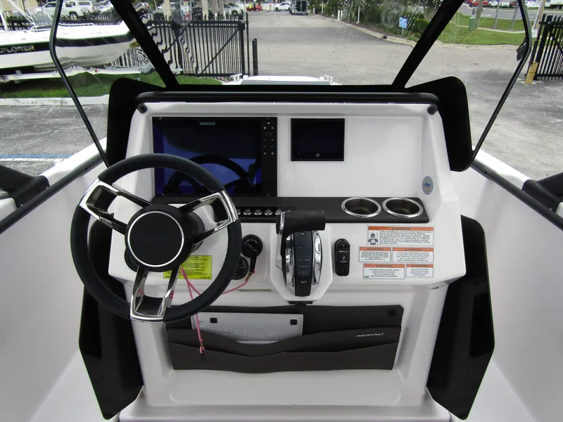 Slide: The Image of 2022 Axopar 22 T-Top boat dashboard with steering wheel and controls. - 12