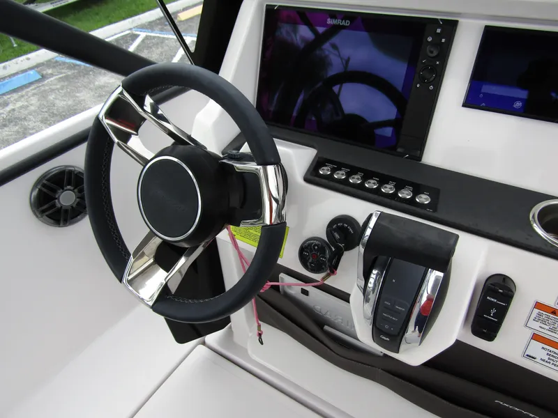 Slide: The Image of 2022 Axopar 22 T-Top boat dashboard with steering wheel and control panel. - 16