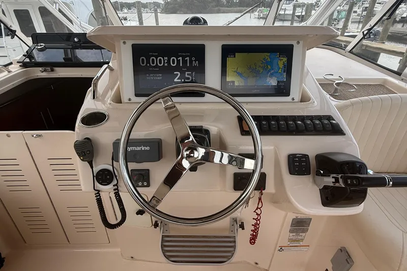 Slide: The Image of Steering console of 2013 Grady-White Express 330 with navigation displays and controls. - 10
