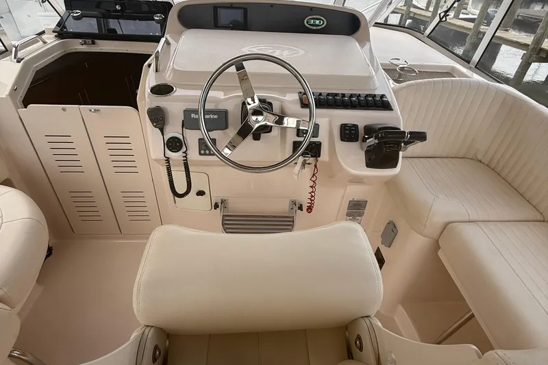 Slide: The Image of 2013 Grady-White Express 330 helm with steering wheel and control panel. - 11