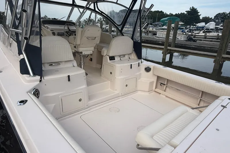 Slide: The Image of 2013 Grady-White Express 330 boat interior at marina, featuring seating and helm. - 17