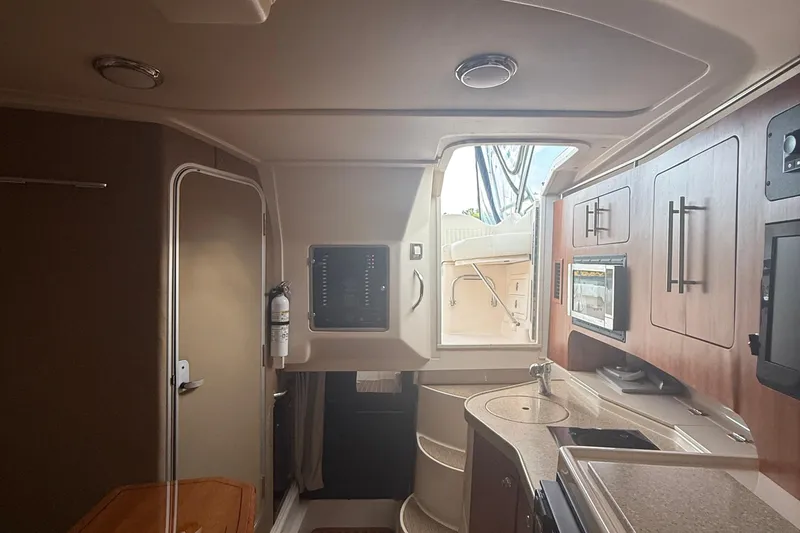 Slide: The Image of Interior of 2013 Grady-White Express 330 boat, featuring kitchenette and modern cabinetry. - 2