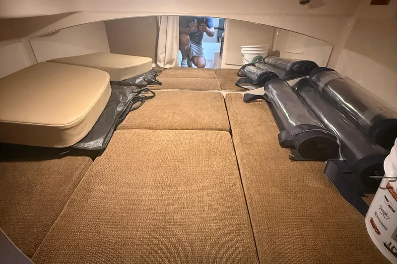 Slide: The Image of 2013 Grady-White Express 330 cabin interior with cushions and storage. - 3