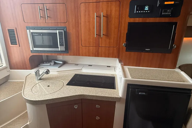 Slide: The Image of 2013 Grady-White Express 330 boat kitchen with microwave, sink, and stove. - 6