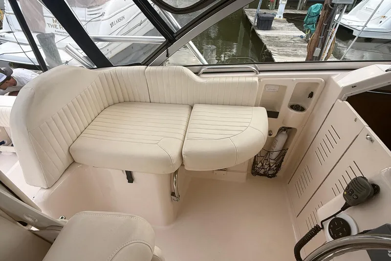 Slide: The Image of 2013 Grady-White Express 330 boat interior with white seating and dock view. - 8