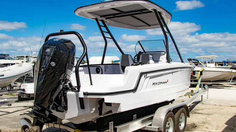 Slide: The Image of 2023 Axopar 22 T-Top boat on a trailer at a marina. - 2