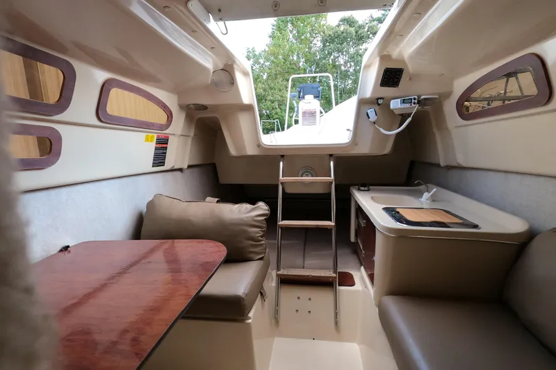 Slide: The Image of Interior of a 2007 MacGregor 26M sailboat with seating, table, and kitchenette. - 20
