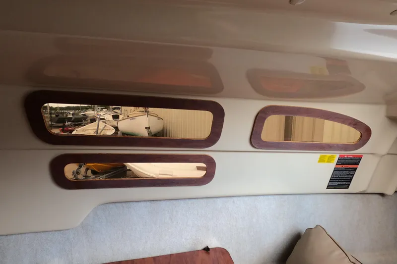 Slide: The Image of Interior view of a 2007 MacGregor 26M sailboat with wooden-framed windows. - 22
