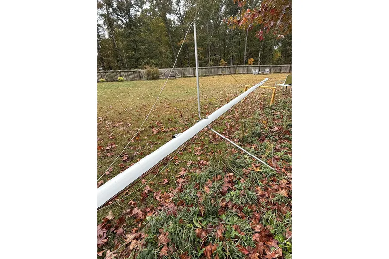 Slide: The Image of Mast of a 2007 MacGregor 26M sailboat lying on grass with autumn leaves. - 29