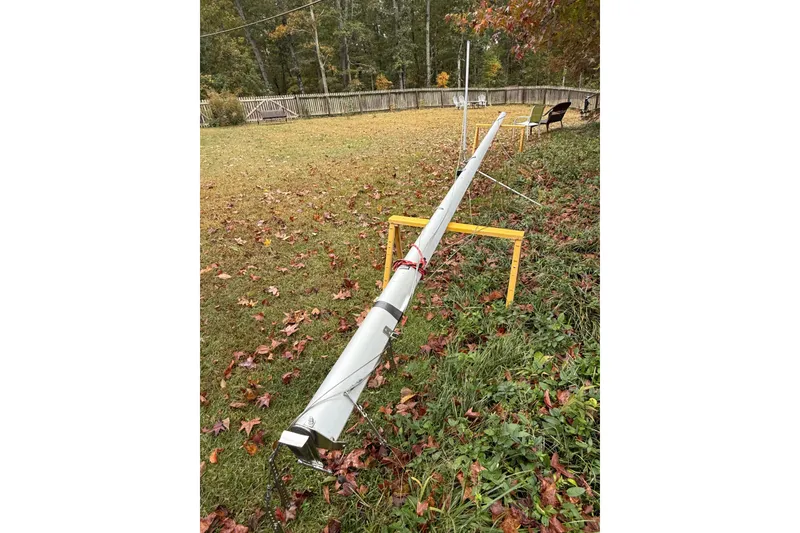 Slide: The Image of Mast of a 2007 MacGregor 26M sailboat lying on grass with autumn leaves. - 31