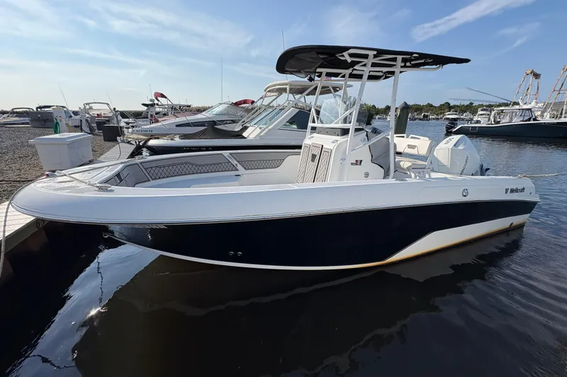The Image of 2021 Wellcraft 202 Fisherman boat docked at marina, featuring sleek black and white design. - 0