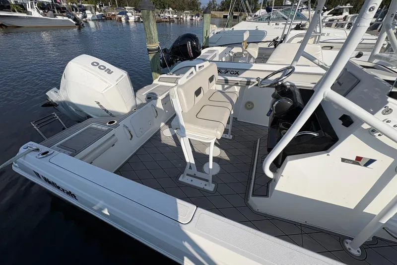 Slide: The Image of 2021 Wellcraft 202 Fisherman boat interior with seating and steering, docked at marina. - 5