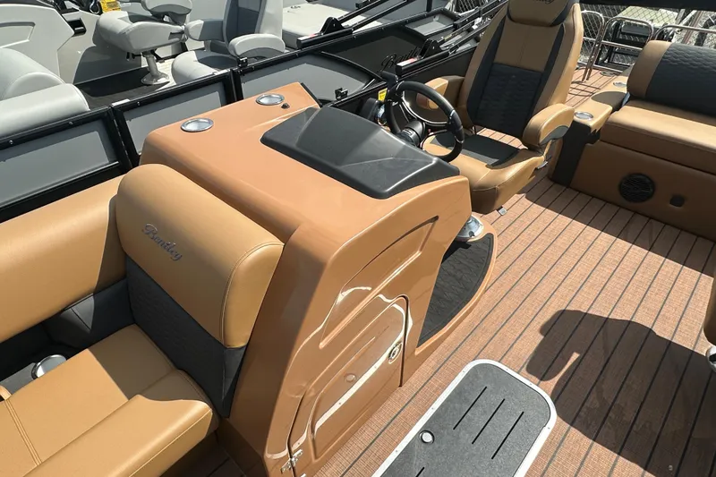 Slide: The Image of 2025 Bentley Pontoons 223 Elite Swingback interior with tan seating and modern dashboard. - 12