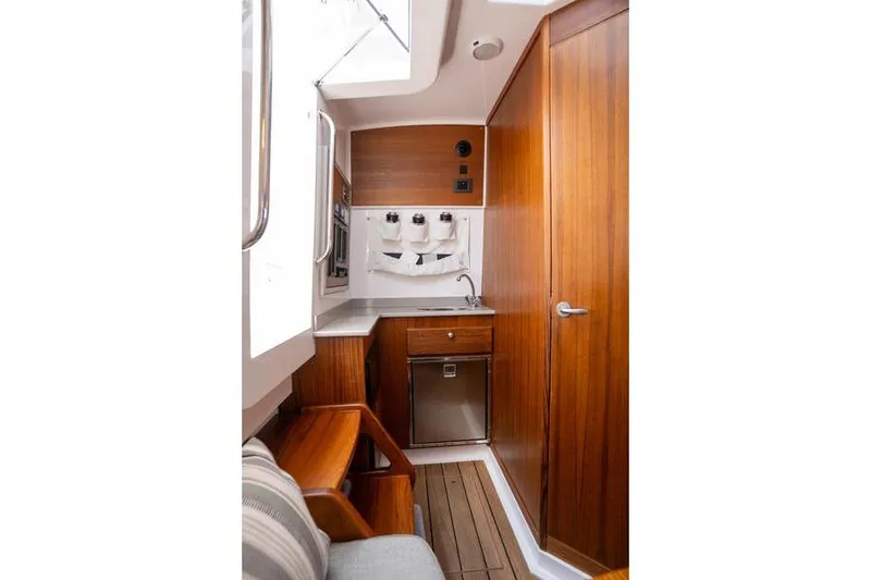 Slide: The Image of 2025 Southport 38 FE boat interior with wooden cabinetry and compact kitchenette. - 29