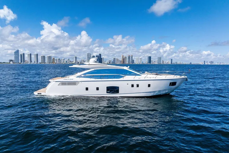 The Image of Luxurious 2013 Absolute 64 yacht cruising on open water with city skyline backdrop. - 0