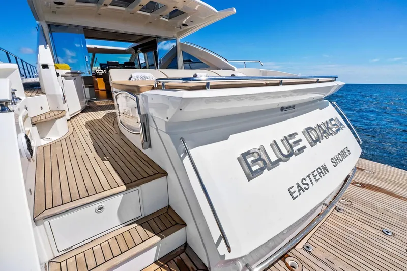 Slide: The Image of Luxurious 2013 Absolute 64 yacht "Blue Drake" on open sea, featuring elegant wooden deck. - 16