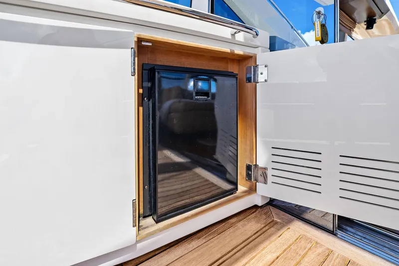 Slide: The Image of Open cabinet on Absolute 64 yacht, revealing a compact refrigerator, 2013 model. - 20