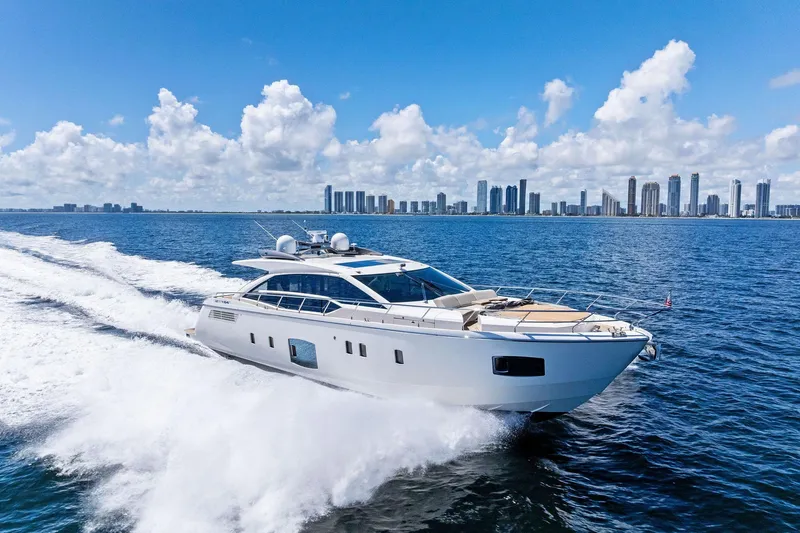 Slide: The Image of Luxurious 2013 Absolute 64 yacht cruising on blue ocean with city skyline backdrop. - 61
