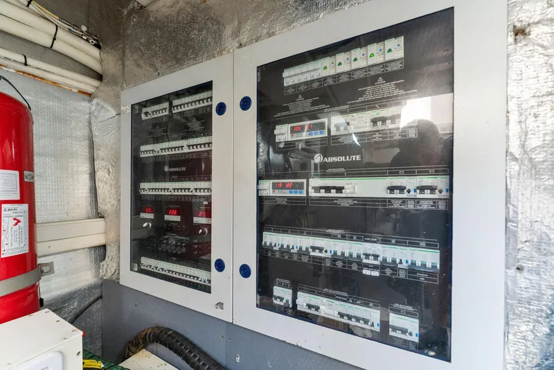 Slide: The Image of Electrical panel inside Absolute 64 yacht, 2013 model, with circuit breakers and fire extinguisher. - 72