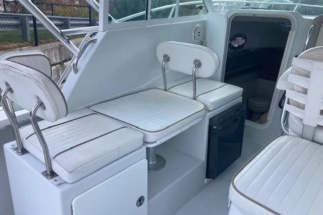 Slide: The Image of 2008 Glacier Bay 2685 Coastal Runner interior with white seating and compact fridge. - 11