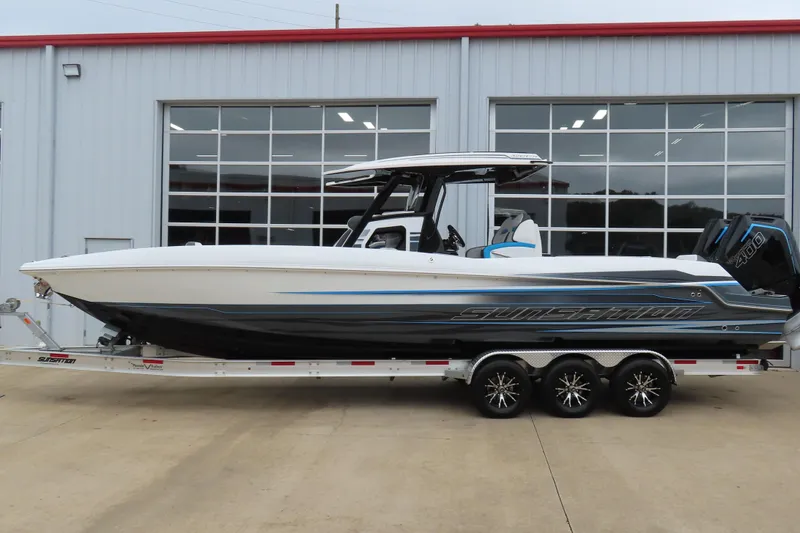 The Image of 2026 Sunsation 32CCX boat on trailer, sleek design, parked outside a modern building. - 0