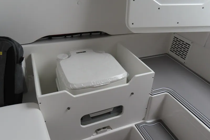 Slide: The Image of Interior of 2026 Sunsation 32CCX boat featuring a compact portable toilet. - 23