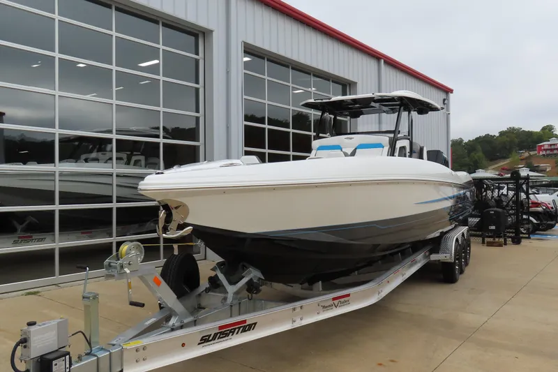 Slide: The Image of 2026 Sunsation 32CCX boat on trailer outside a showroom, showcasing sleek design and modern features. - 3