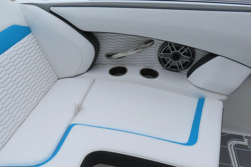 Slide: The Image of 2026 Sunsation 32CCX boat interior with white and blue seating, speaker, and cup holders. - 8