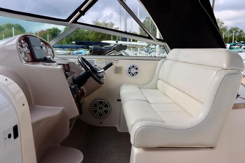 Slide: The Image of 2006 Rinker 360 Express Cruiser interior with white seating and helm controls. - 10